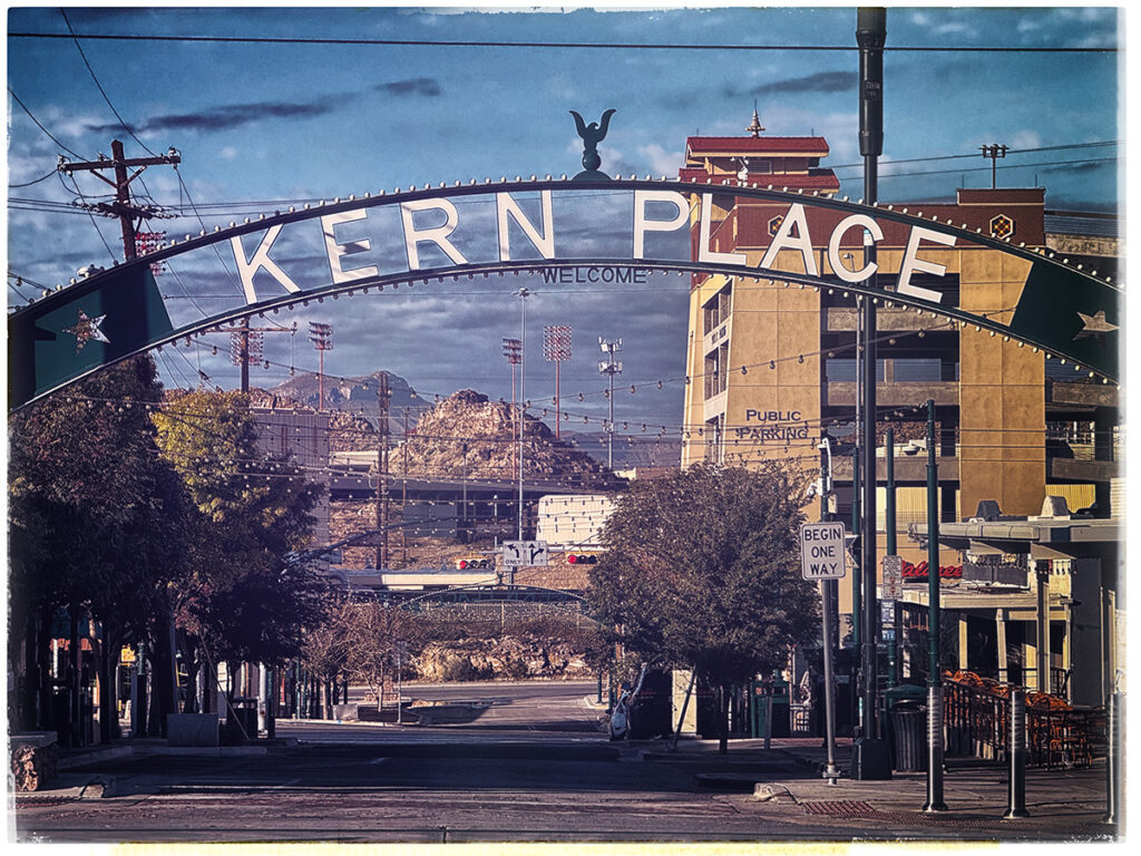 Kern Place entrance sign over Cincinnati St with mountains in the background.